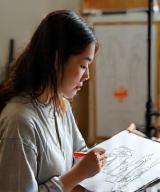 Sarah Lim in studio, sketching hoodie concepts
